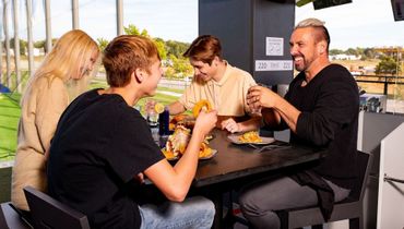 A group of people are sitting at a table eating food.