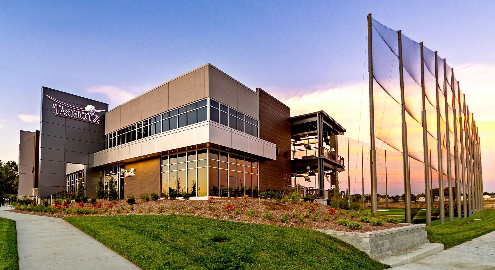 A large building with a lot of windows and a sunset in the background