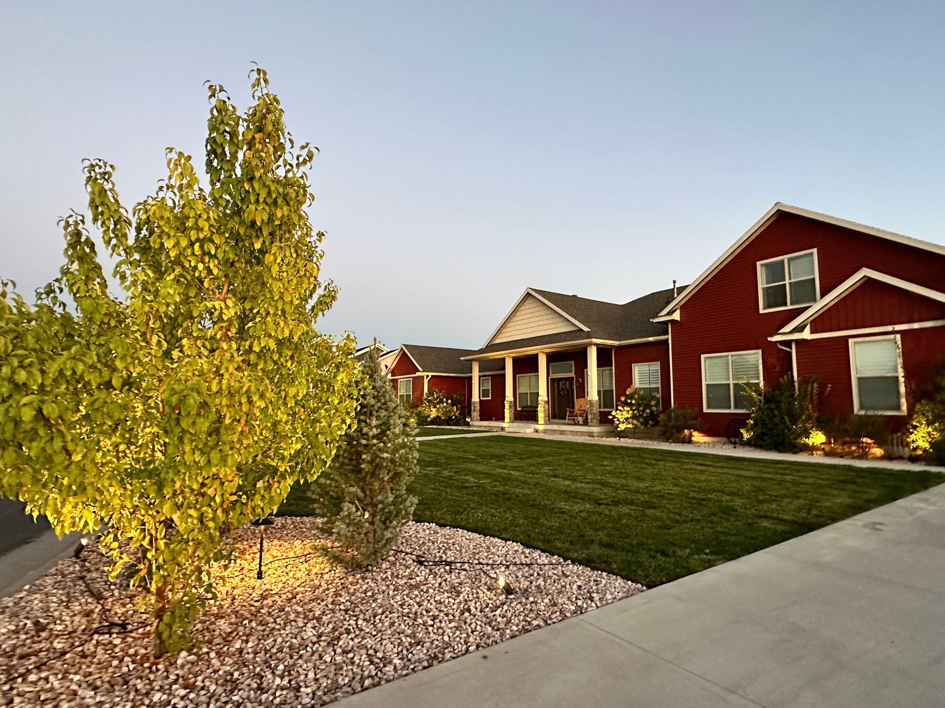 A large red house with a large lawn in front of it