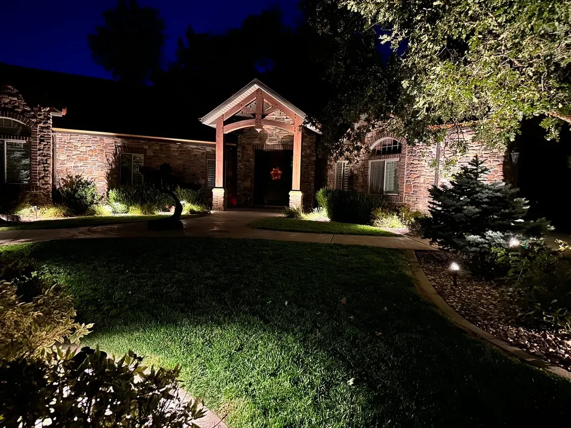 The front of a house is lit up at night.