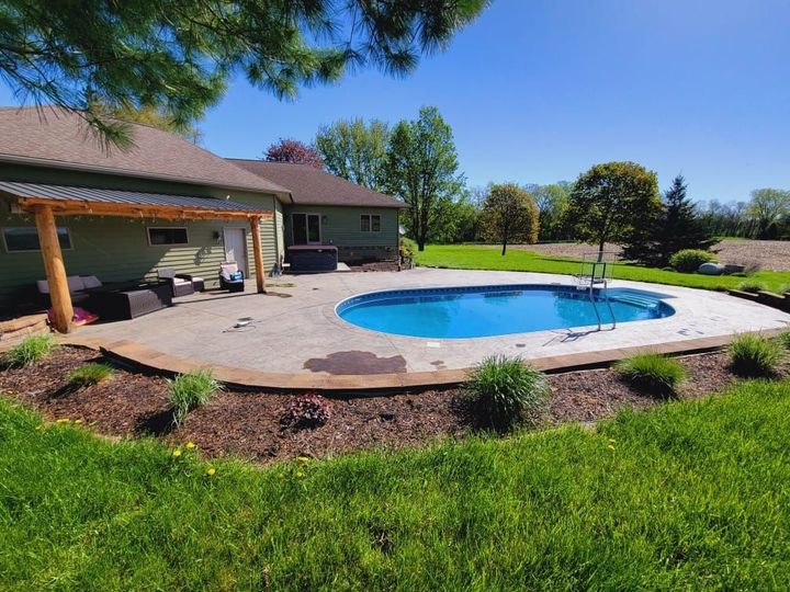 A large blue swimming pool is being built in a backyard.