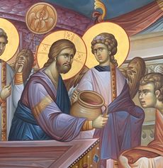 Religious icon painting of Jesus and angels with halos, holding a jar at a table.