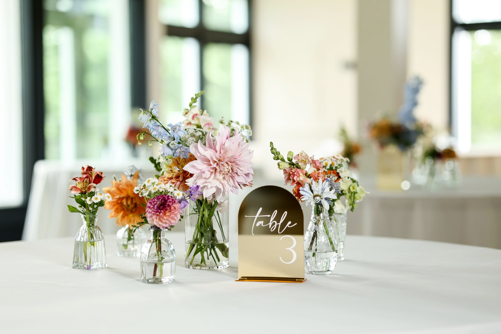 A large white house sits on the shore of a lake