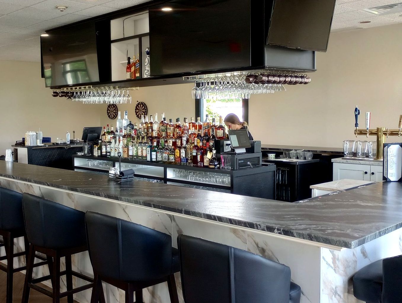 A bar with a lot of bottles of liquor on it.