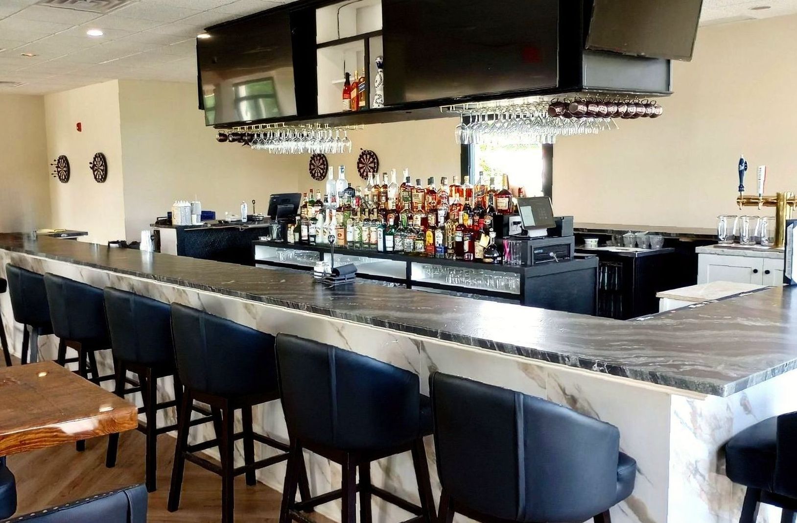 A long bar in a restaurant with a lot of bottles on it.