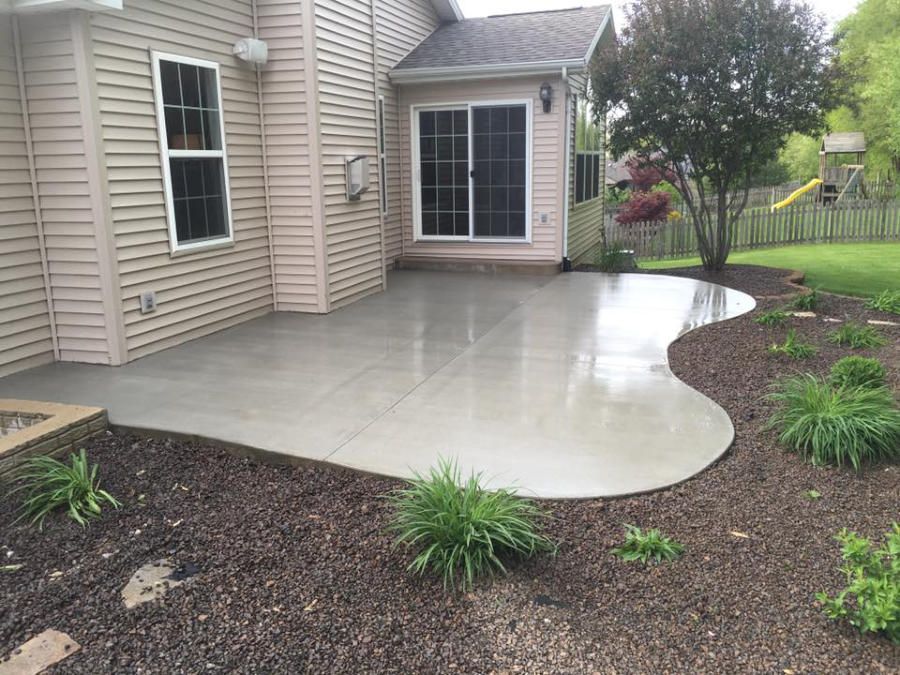 There is a patio in the backyard of a house.