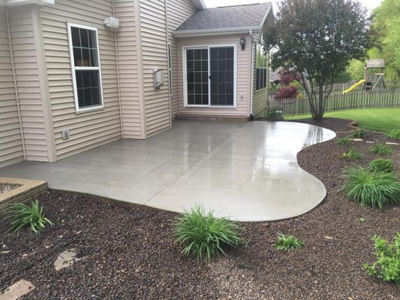 There is a patio in the backyard of a house.
