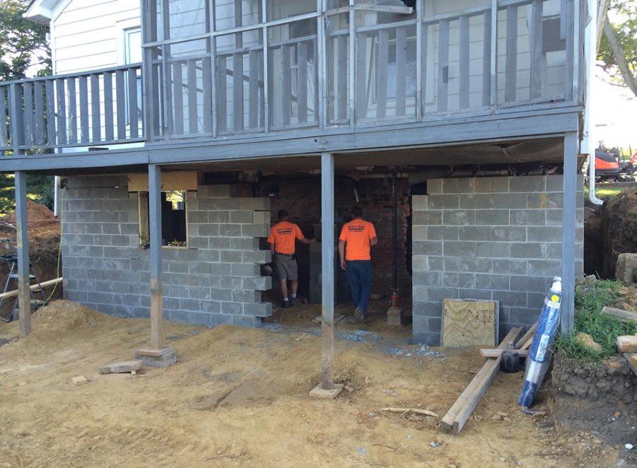 A group of men are standing in front of a basement under construction.