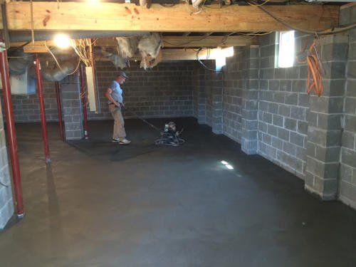 A man is standing in a basement in construction | Jack-A-Slab Construction