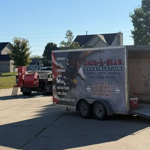 Construction trailer and red equipment parked on a sunny suburban street