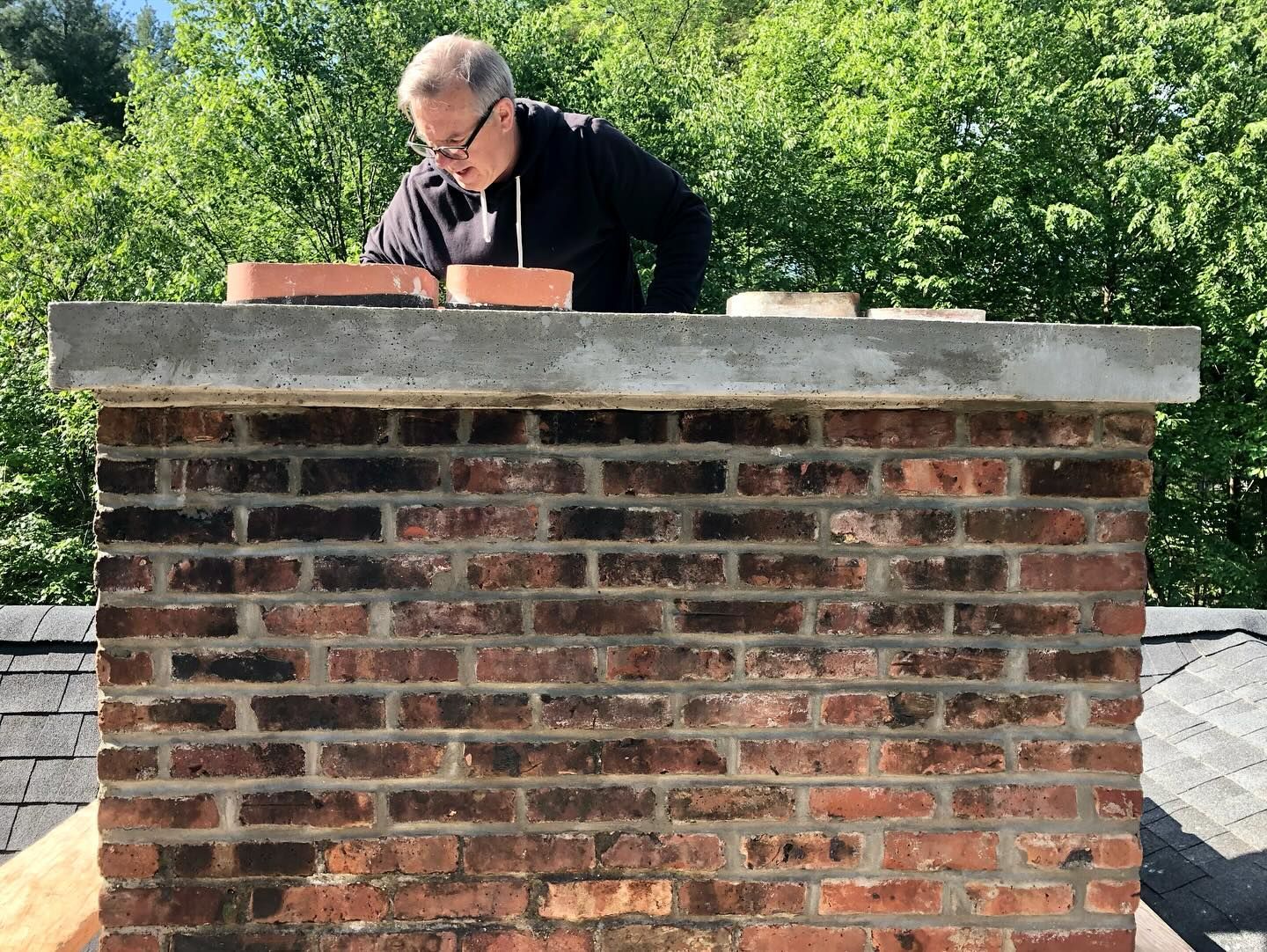 Looking down into a cylindrical, weathered pipe, showing interior layers of grime and discoloration.