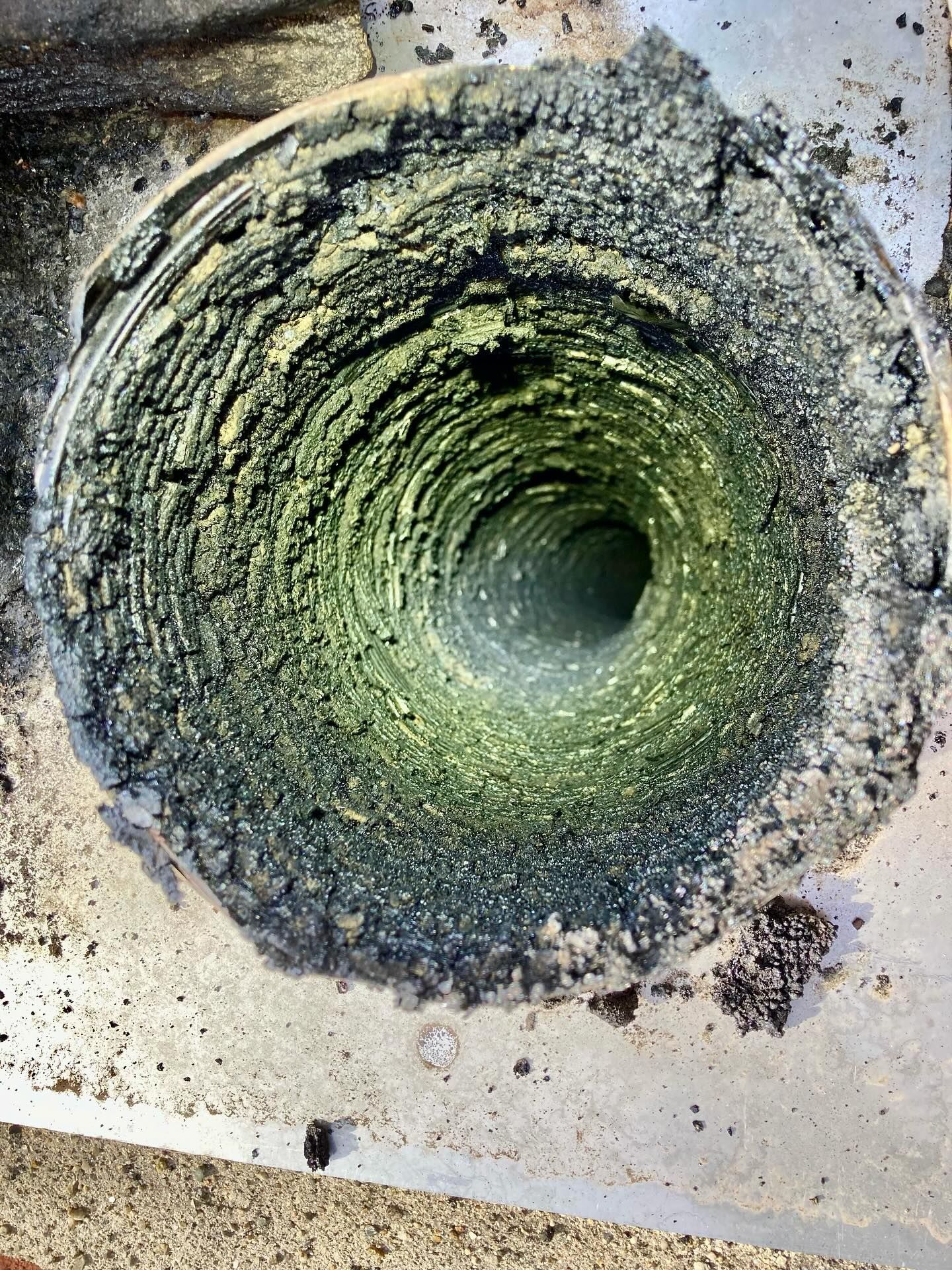 Chimney flue caked with thick, dark green and black creosote buildup.