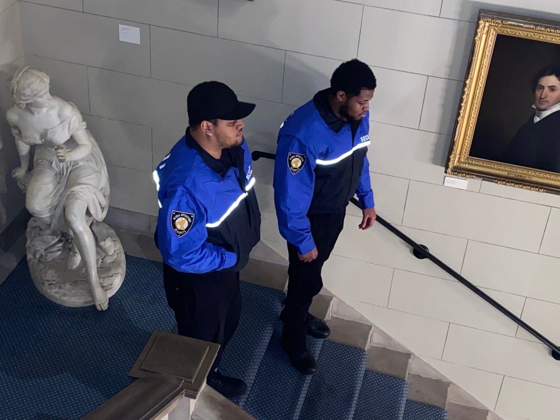 Two security guards patrolling inside an art gallery