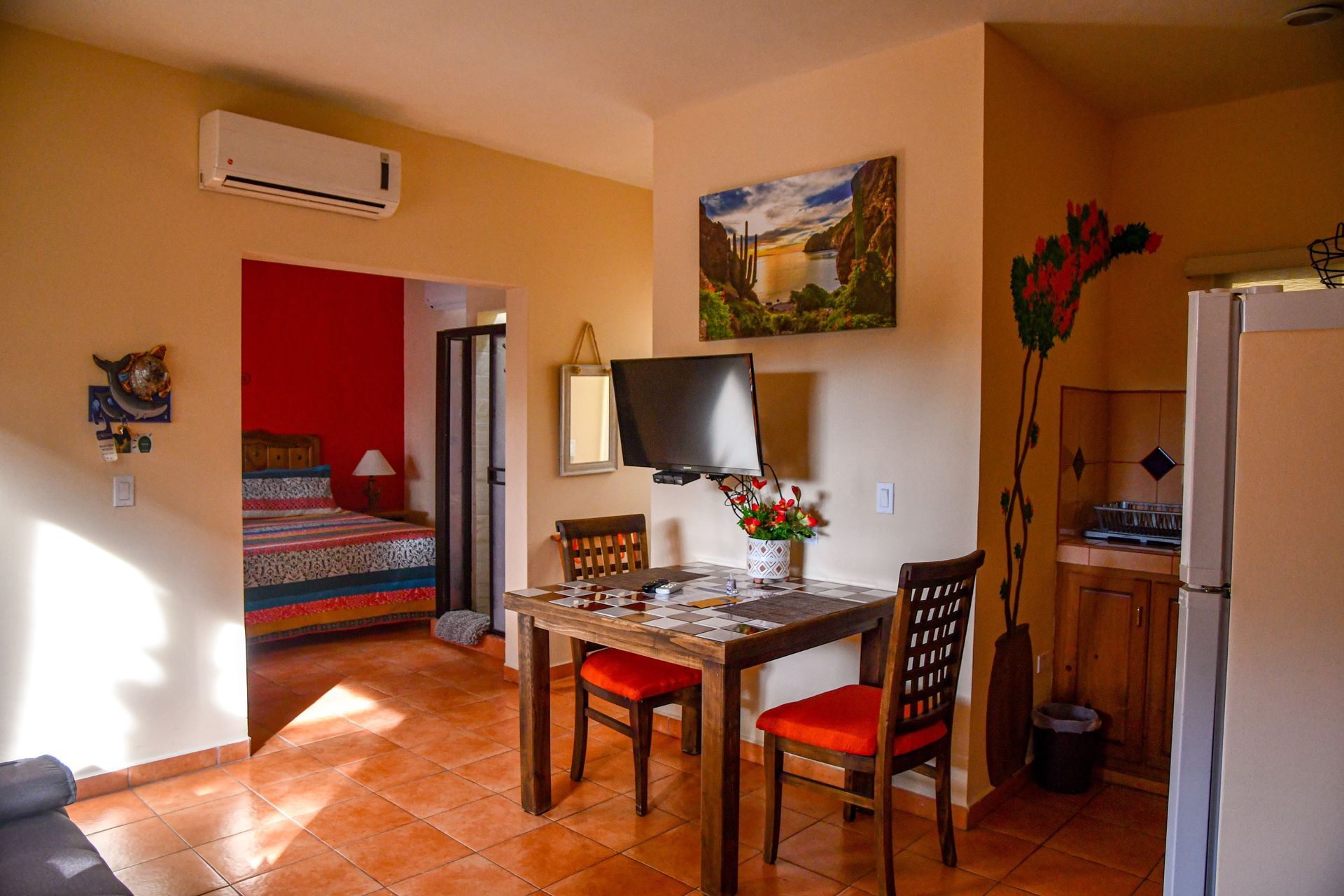 A living room with a table and chairs and a television.