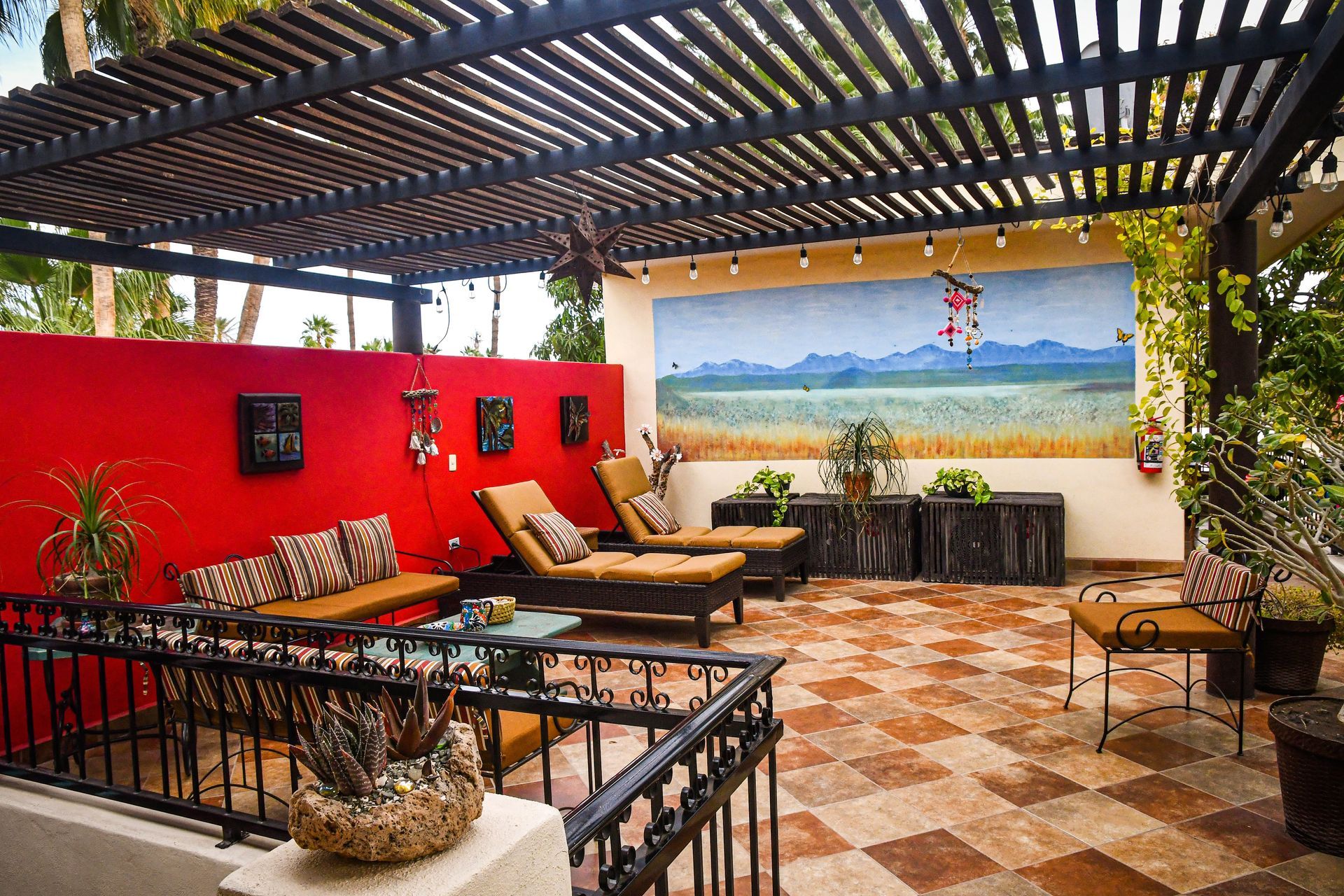 A patio with a pergola and a painting on the wall
