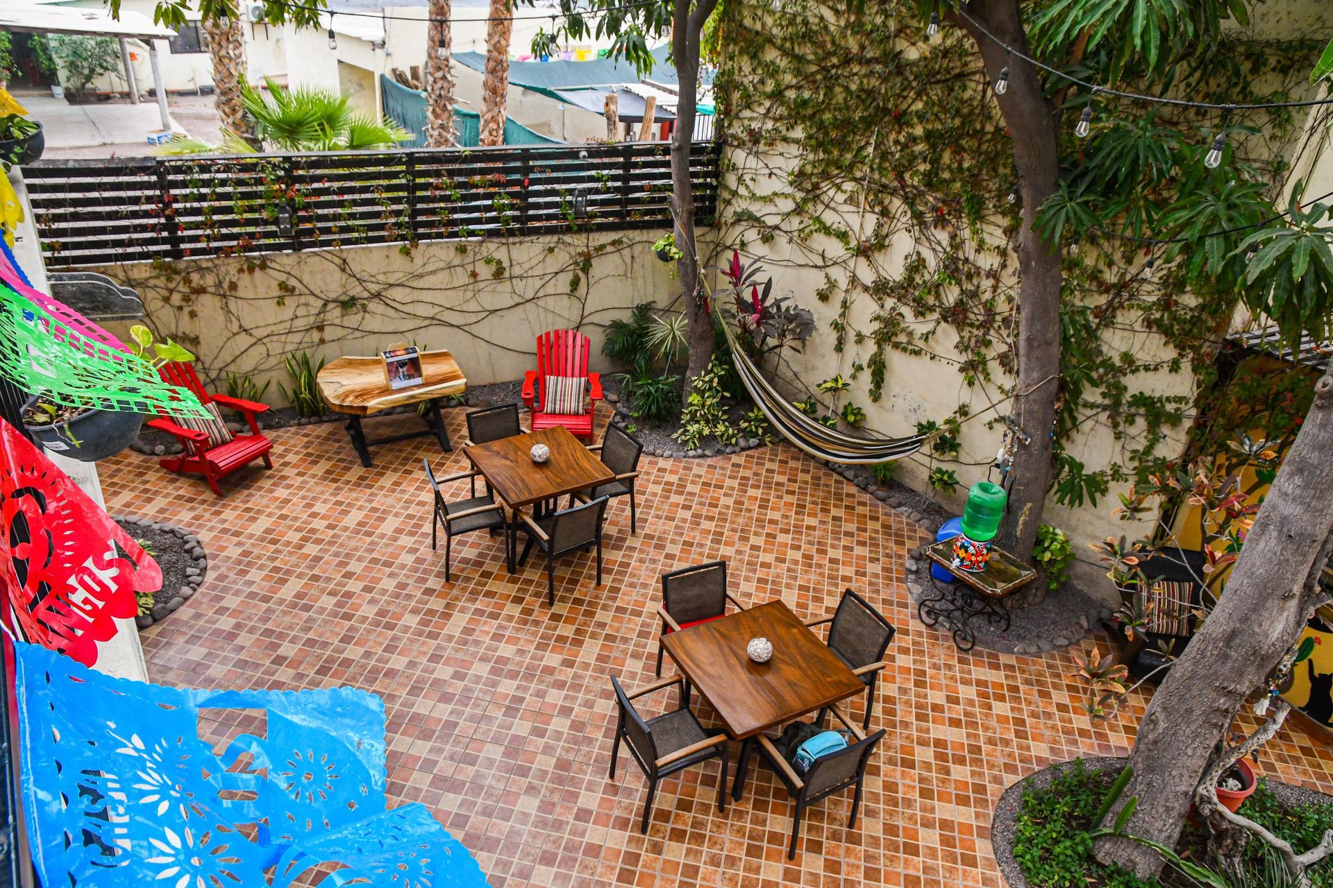 An aerial view of a patio with tables and chairs and a hammock.