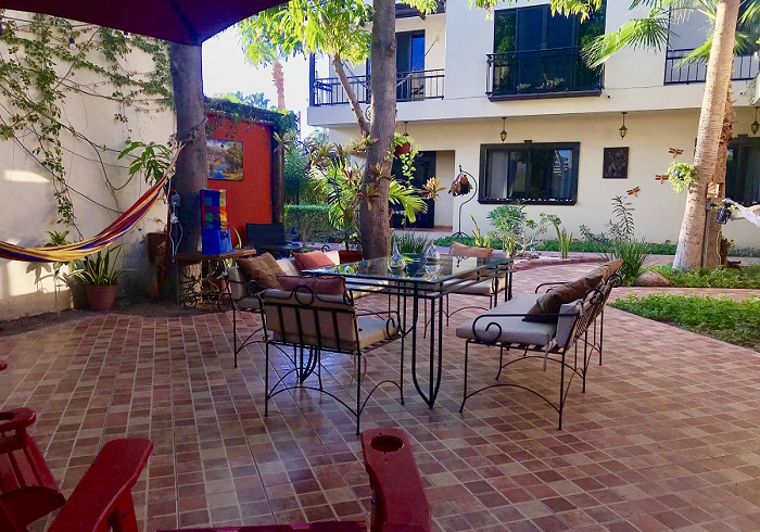 A patio with a table and chairs in front of a building