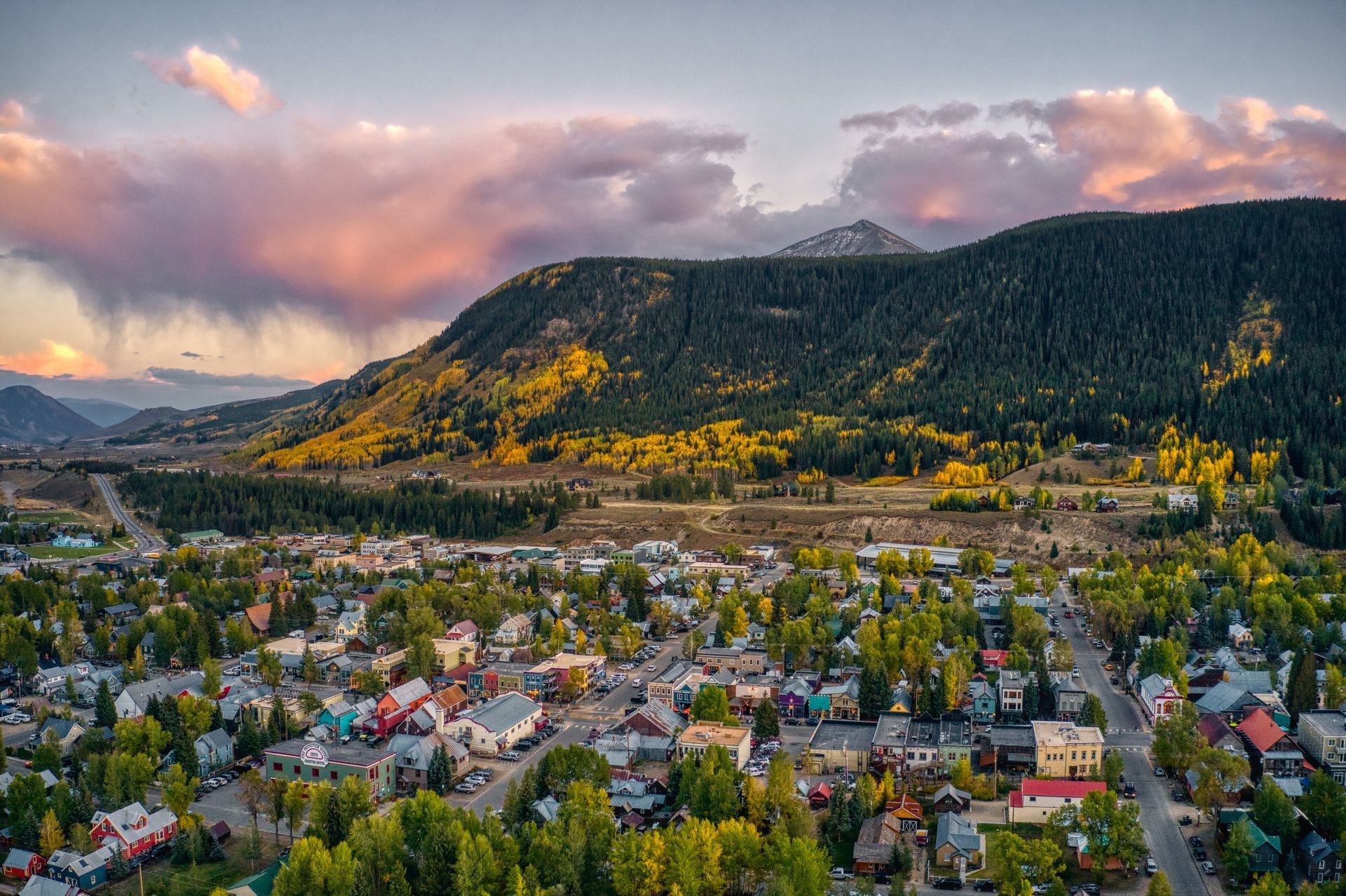 an aerial view of a small town with mountains in the background .