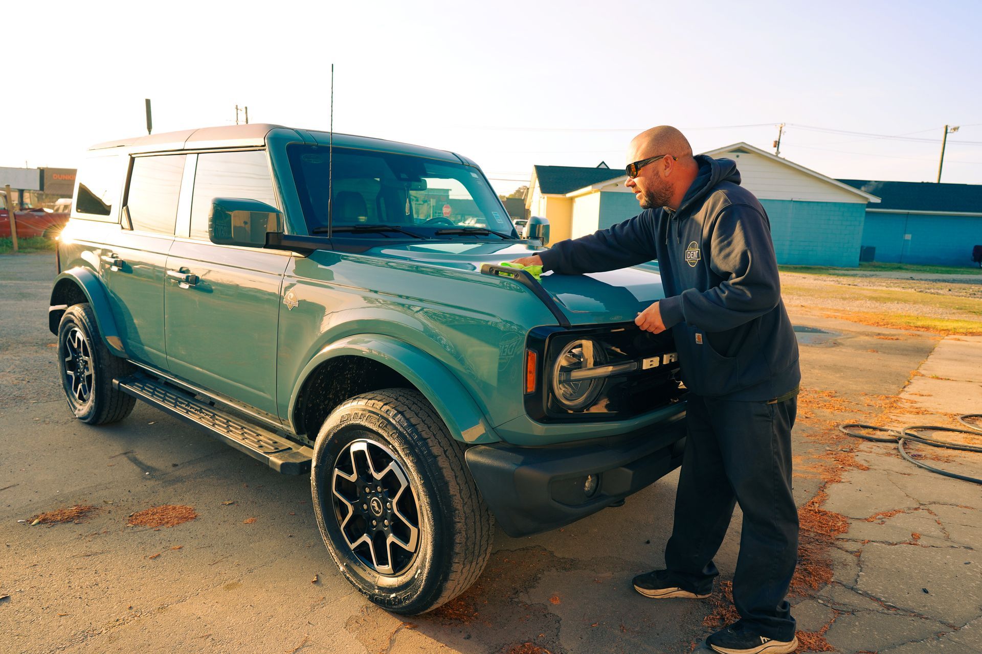 Teal Ford Bronco with hail damage being repaired by PDR specialist in Summerville, SC. All insurances accepted.