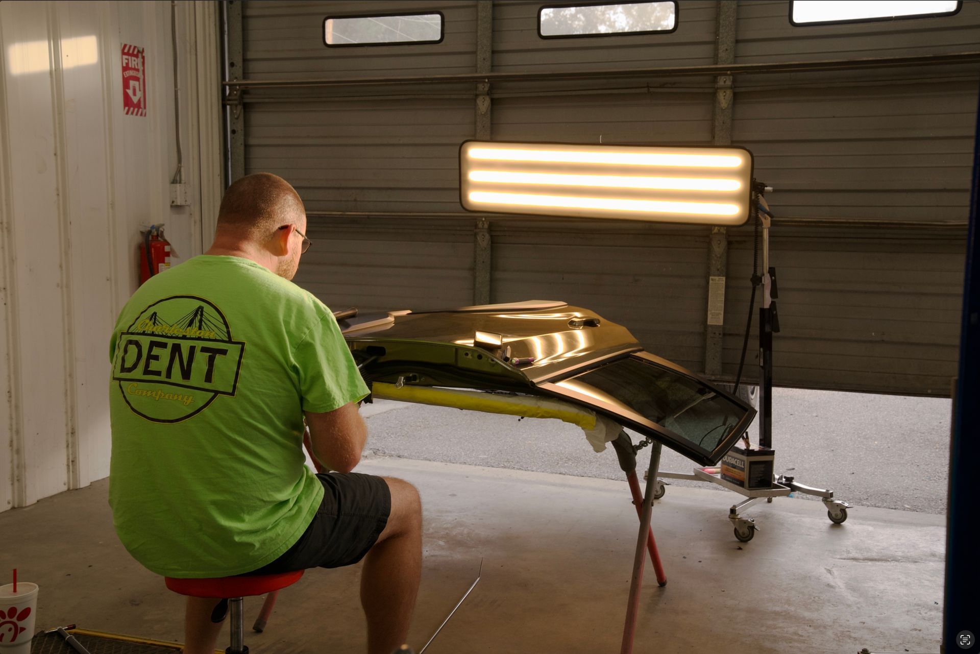 Charleston Dent Company technician performing paintless dent repair (PDR) on the door of a Subaru forester in Summerville, SC. 