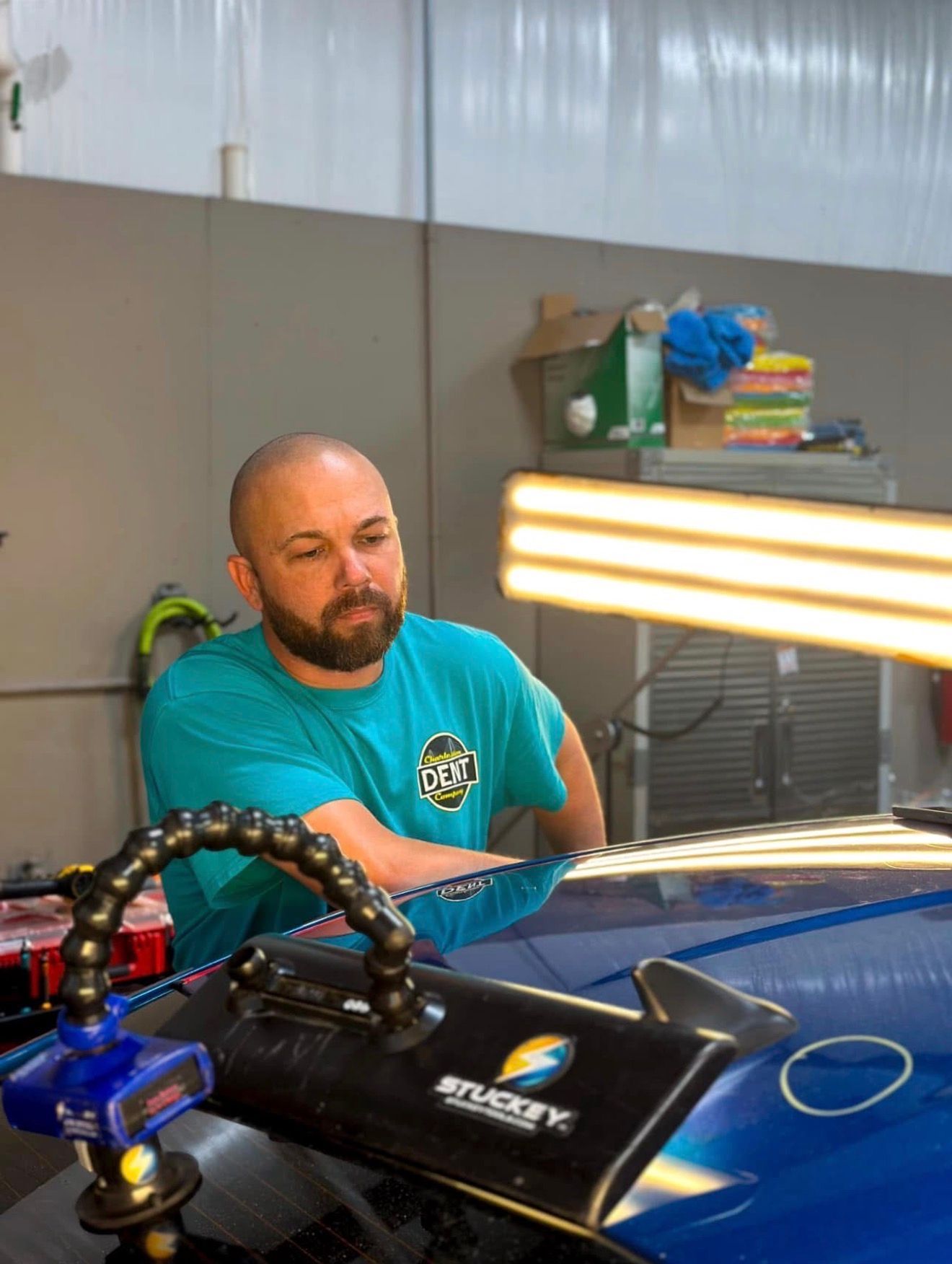 Charleston Dent Company technician repairing hail damage on the roof of a Honda accord In Summerville, Sc. using special LED lighting