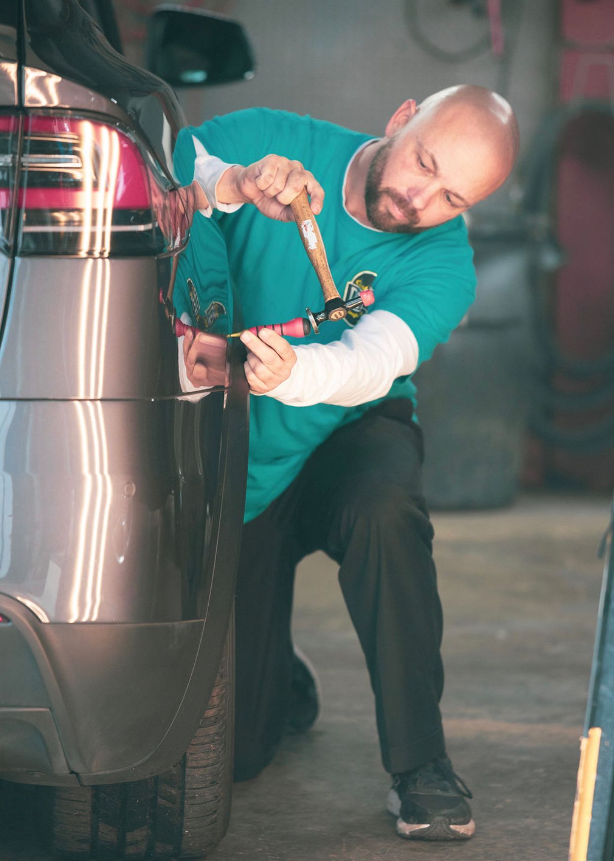 Charleston Dent Company technician using special PDR tools to repair a Tesla model 3 rear quarter panel in the area of Cane Bay in Berkeley county SC. 