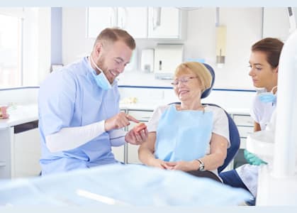 dentist showing patient dentures