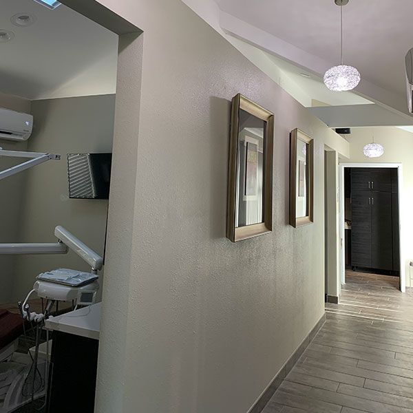 A long hallway in a dental office with mirrors on the wall