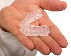 A person is holding a clear mouth guard in their hand