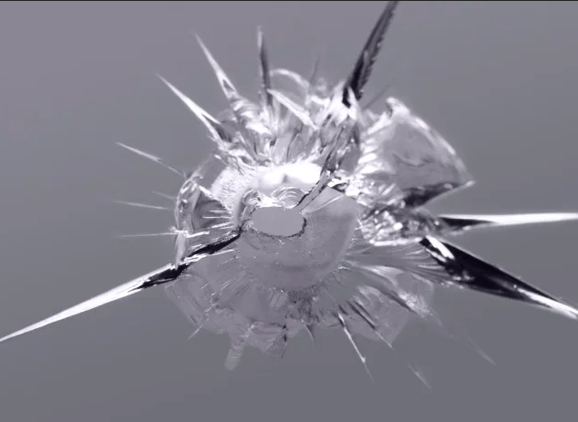 Shattered glass pane with radial cracks and shards, against a gray background.