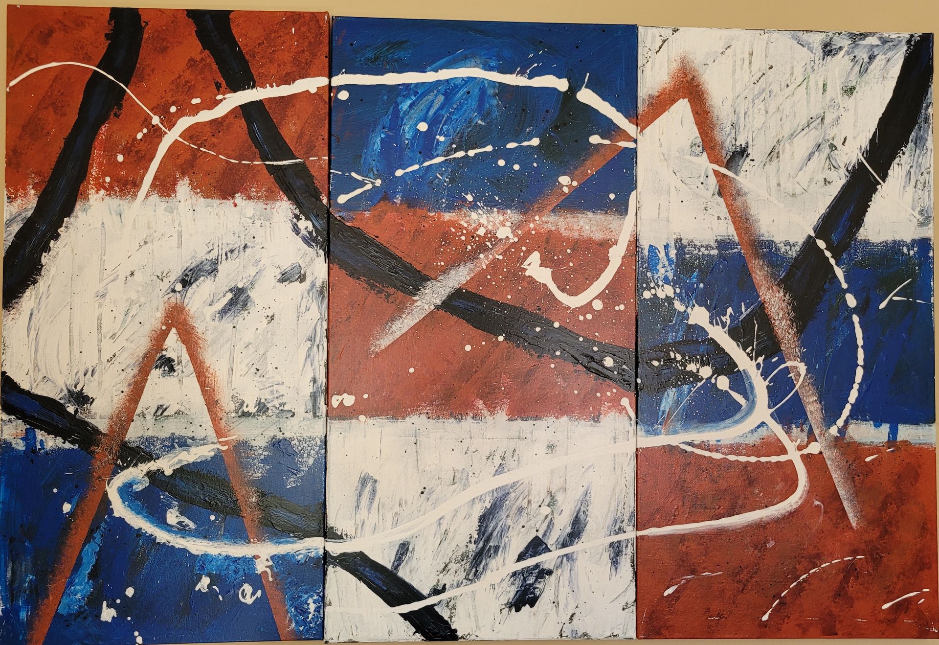 Une peinture abstraite rouge, blanche et bleue sur un mur