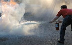 A man putting out a fire with an extinguisher