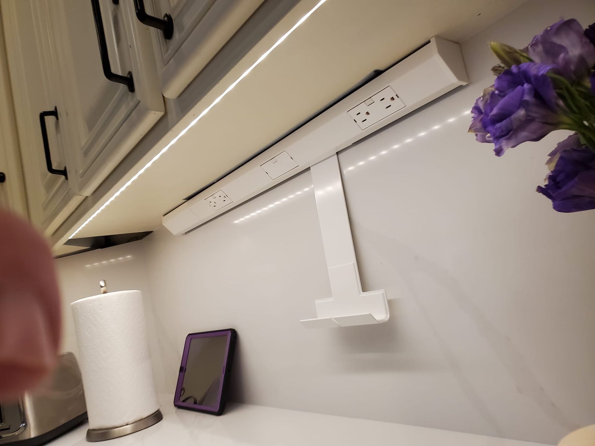 A kitchen with purple flowers and a phone on the counter