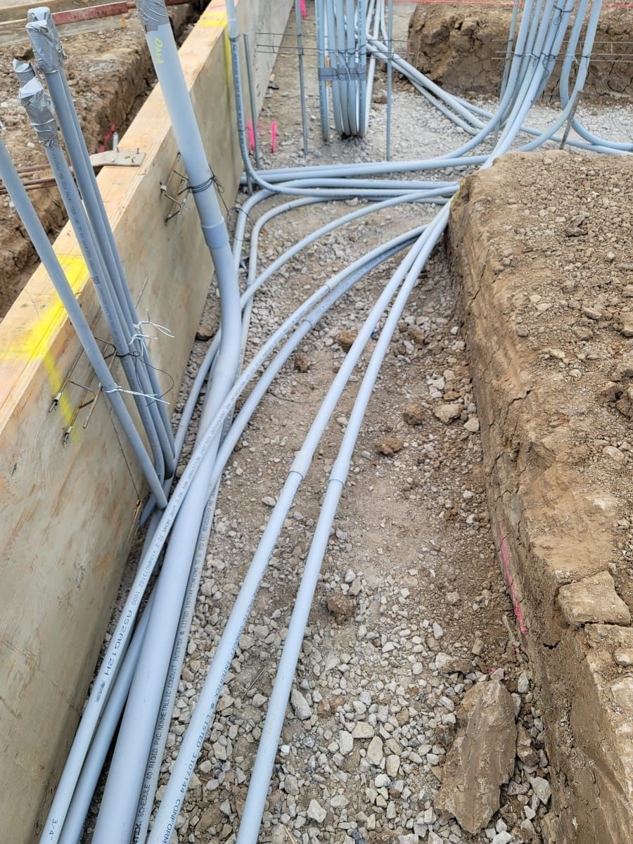 A bunch of electrical wires are laying in the dirt.