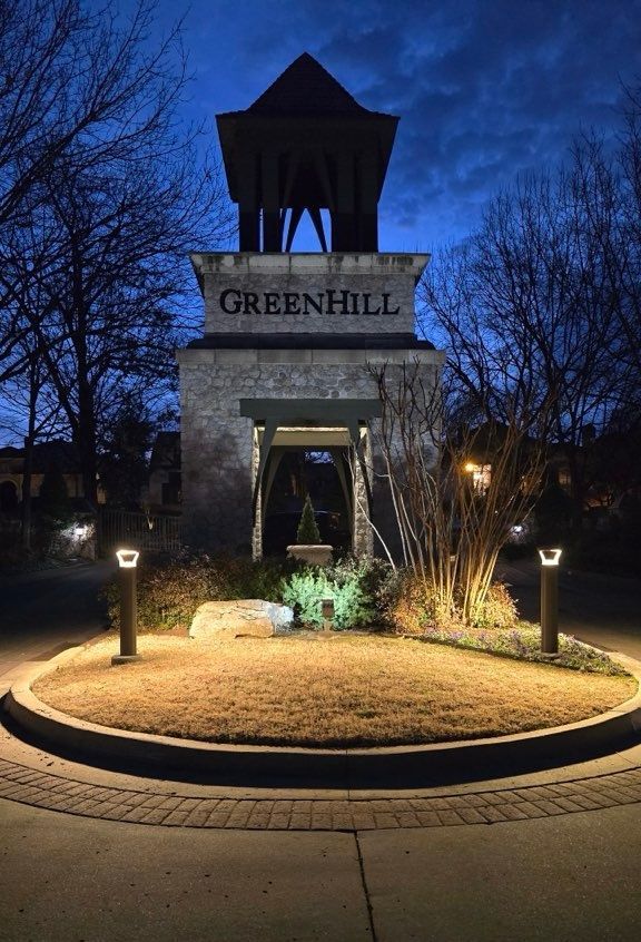 A twilight view of a stone monument with a bell tower labeled 