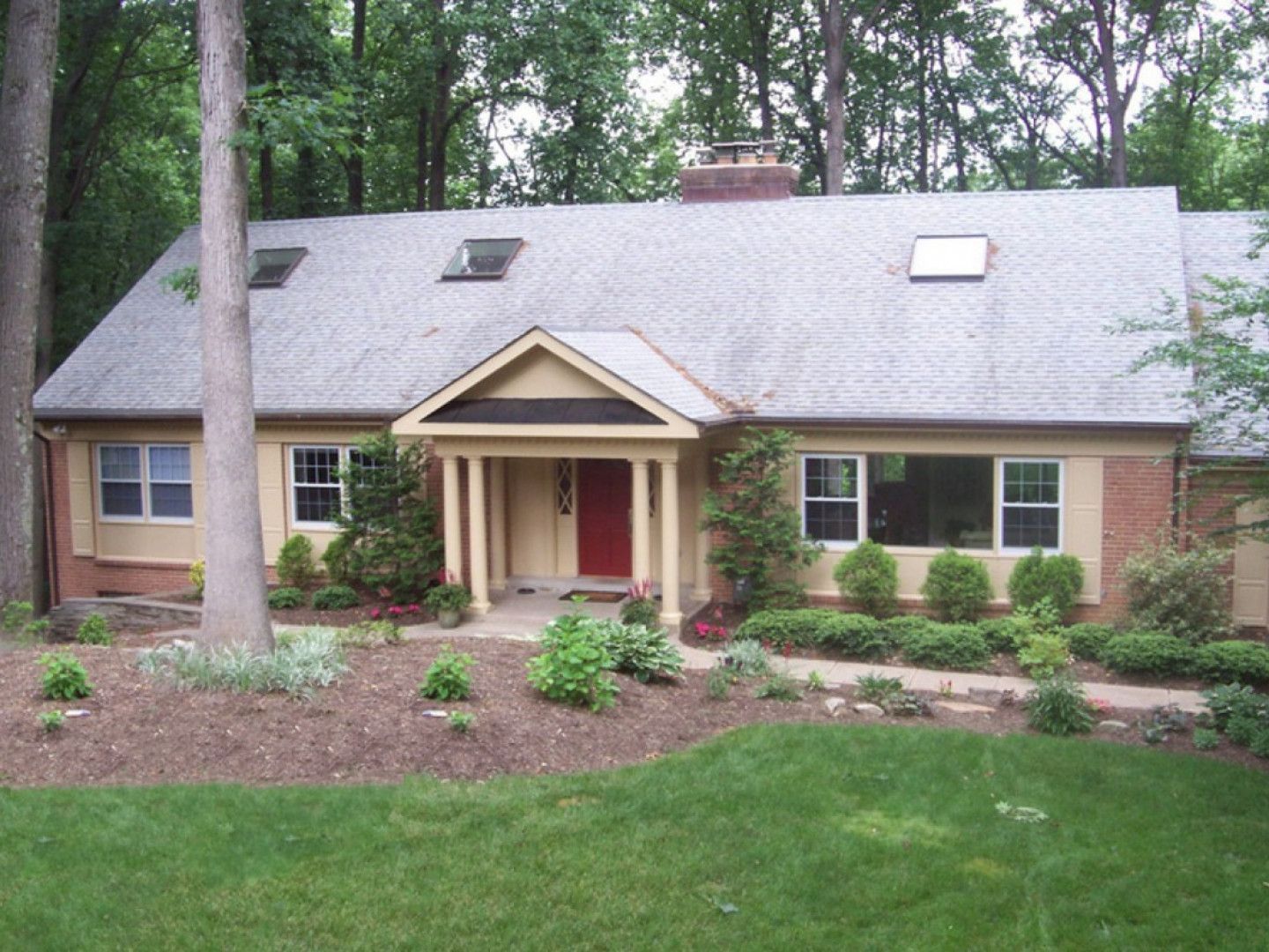 A house with a gray roof and a red door