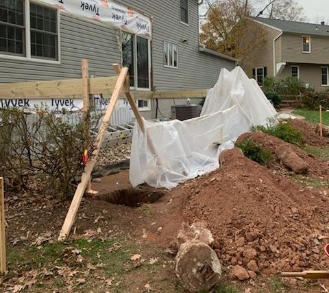 A large pile of dirt is sitting in front of a house.