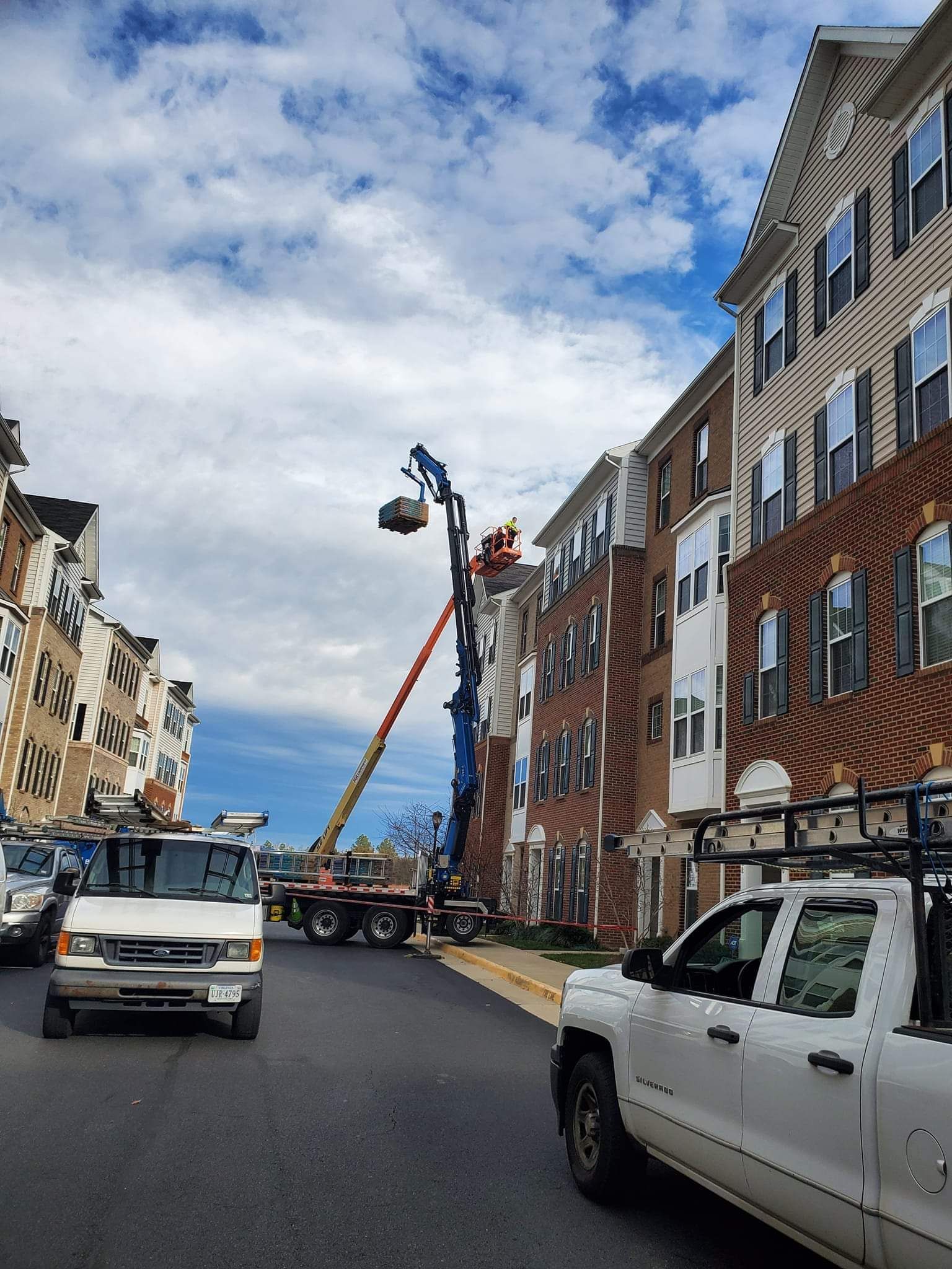 A white truck is parked on the side of the road in front of a building.