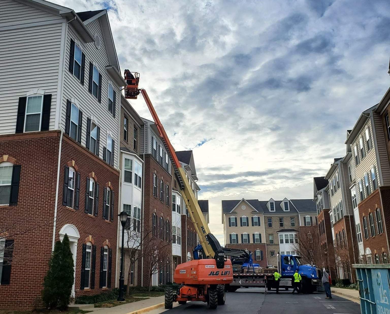 A crane is being used to clean the roof of a building.