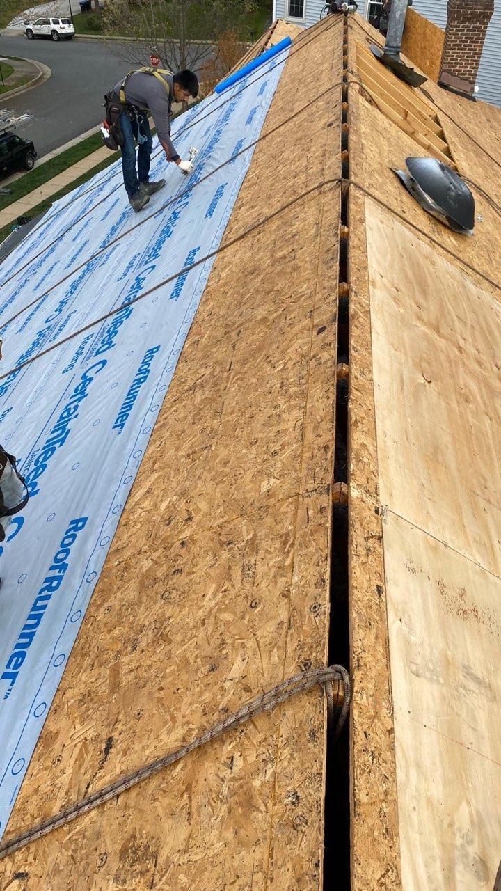 A man is working on the roof of a house.