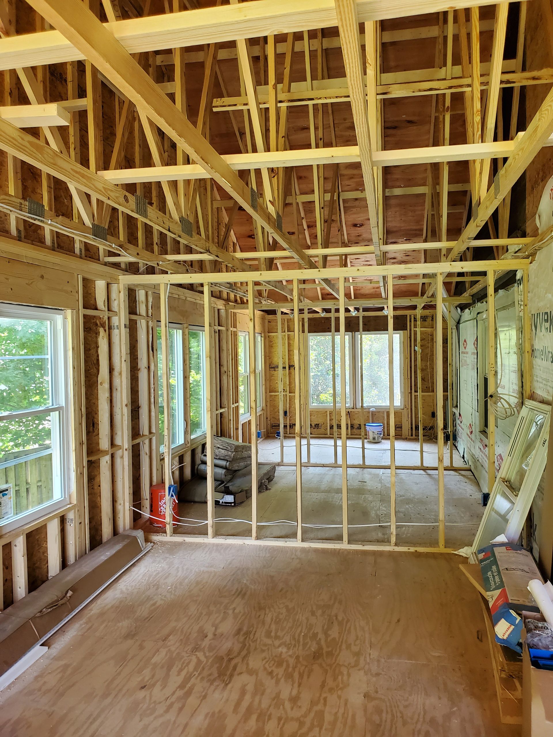 A room in a house under construction with a lot of wooden beams.