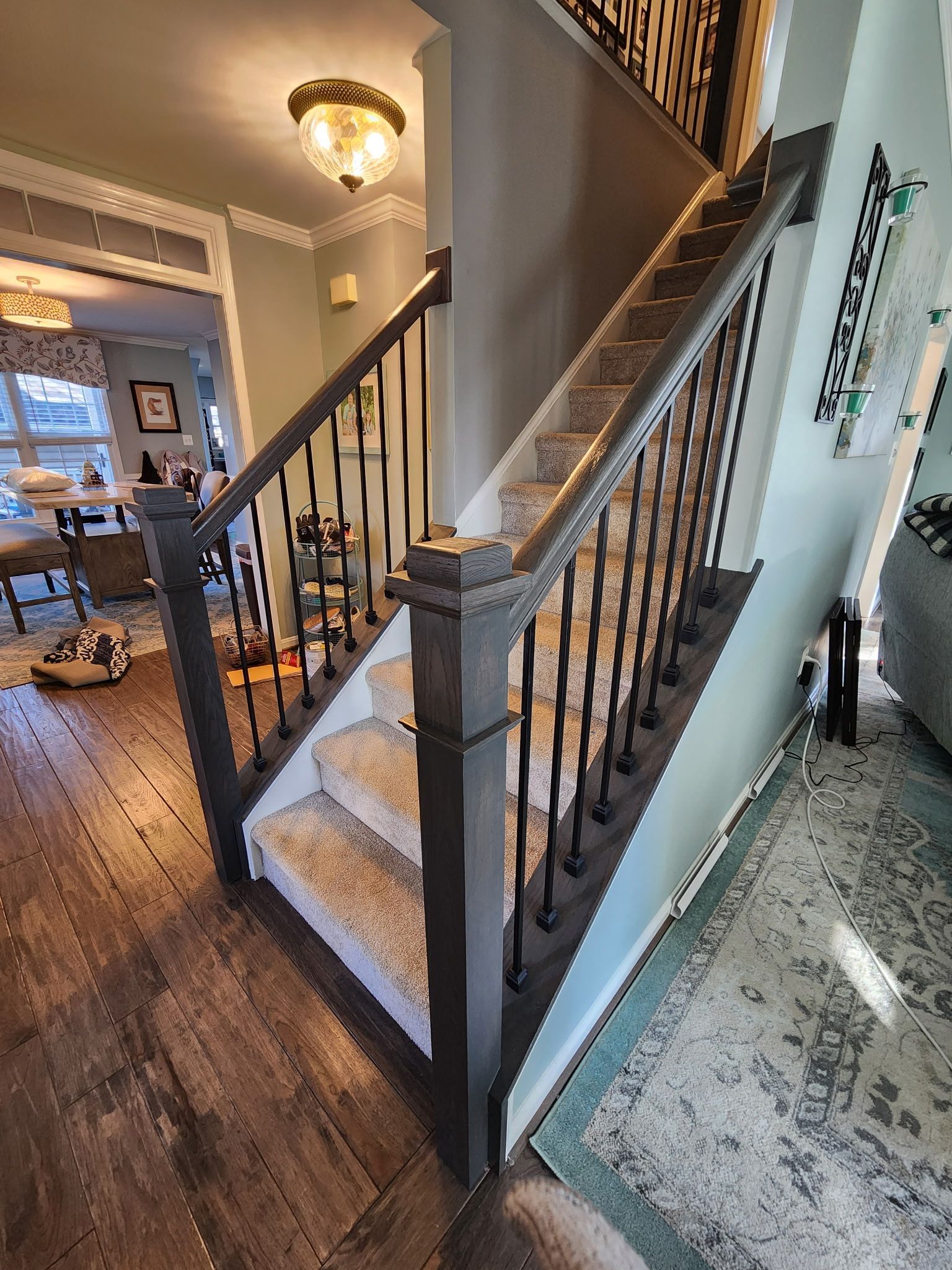 Staircase with dark gray banister and carpeted steps, leading to an upper level.