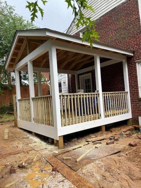 A porch is being built on the side of a brick house.