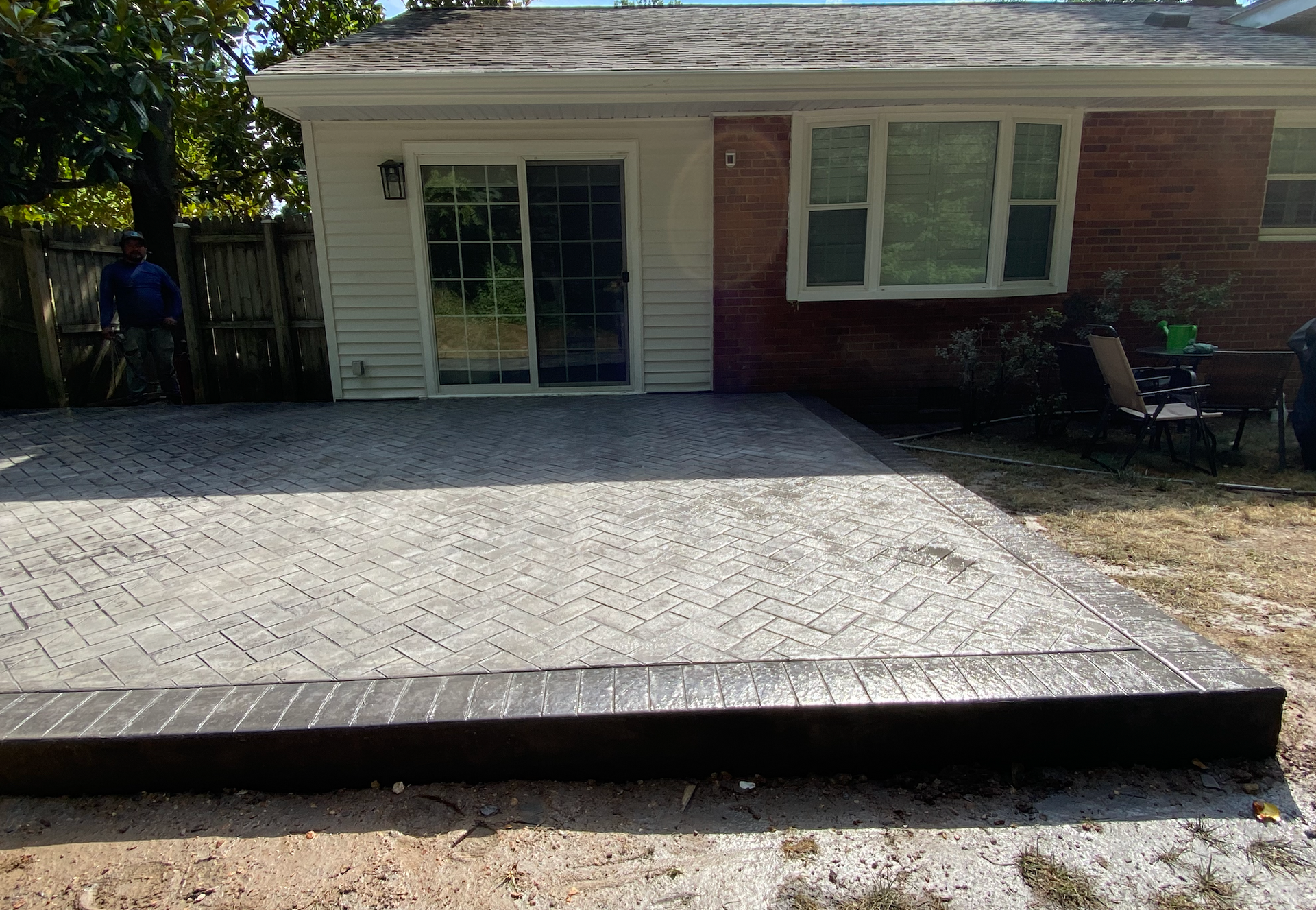 A brick house with a concrete patio in front of it.