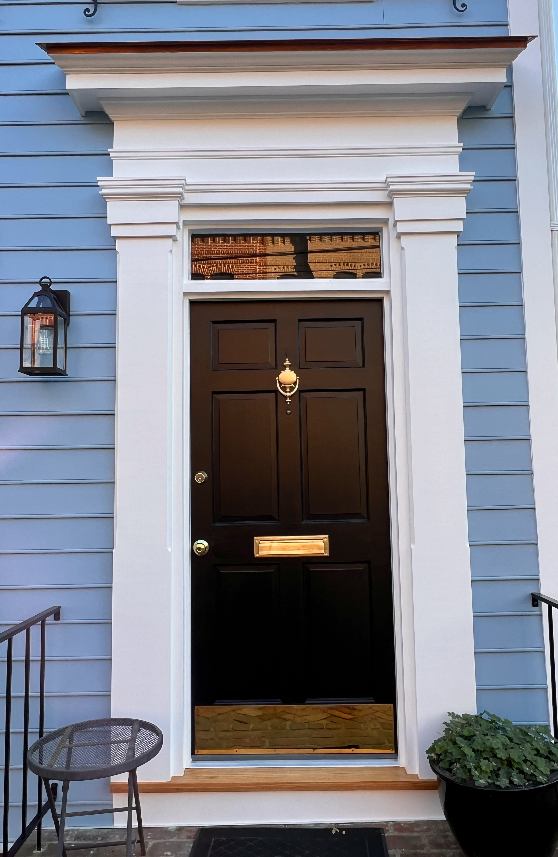 A blue house with a black door and white trim