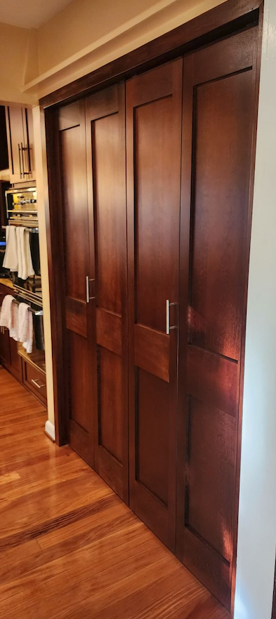 A closet with sliding wooden doors and hardwood floors.