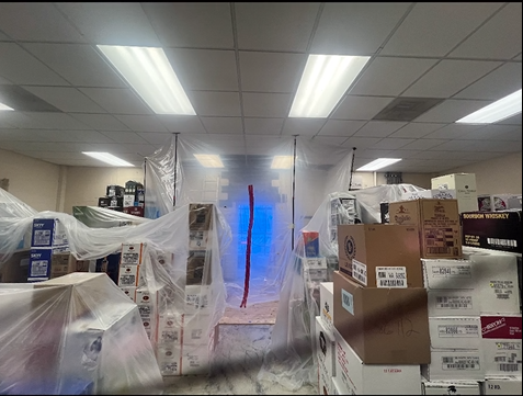 A room with boxes stacked on top of each other and a blue light coming out of the ceiling.