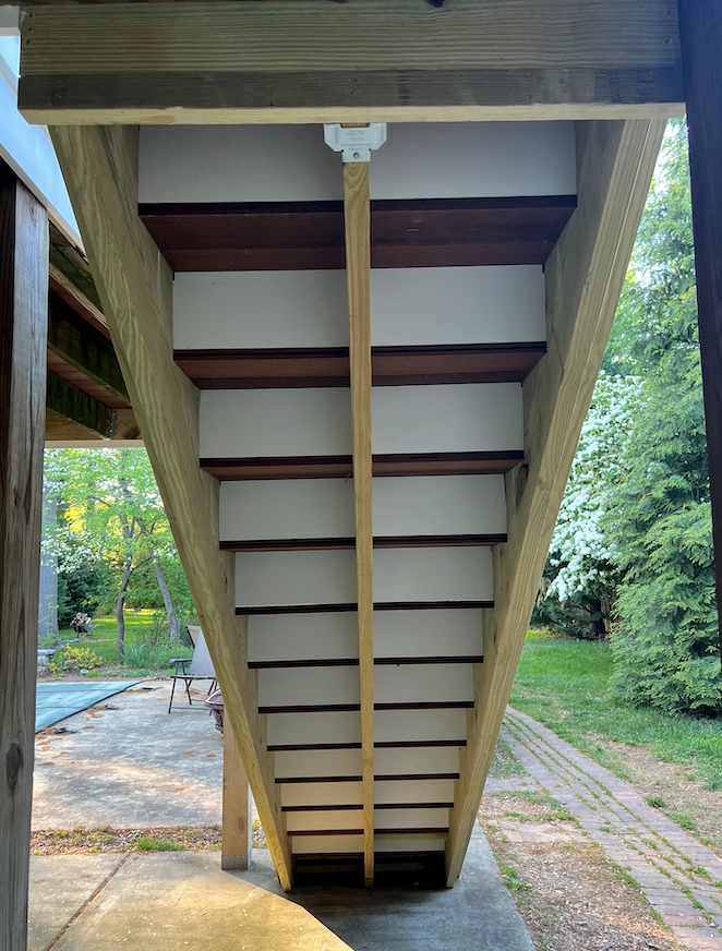 A wooden staircase is built into the side of a house.