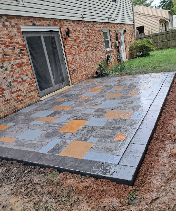 A patio is being built in front of a brick house.