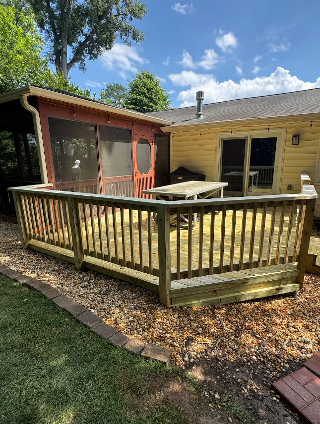 A wooden deck with a screened in porch in the backyard of a house.